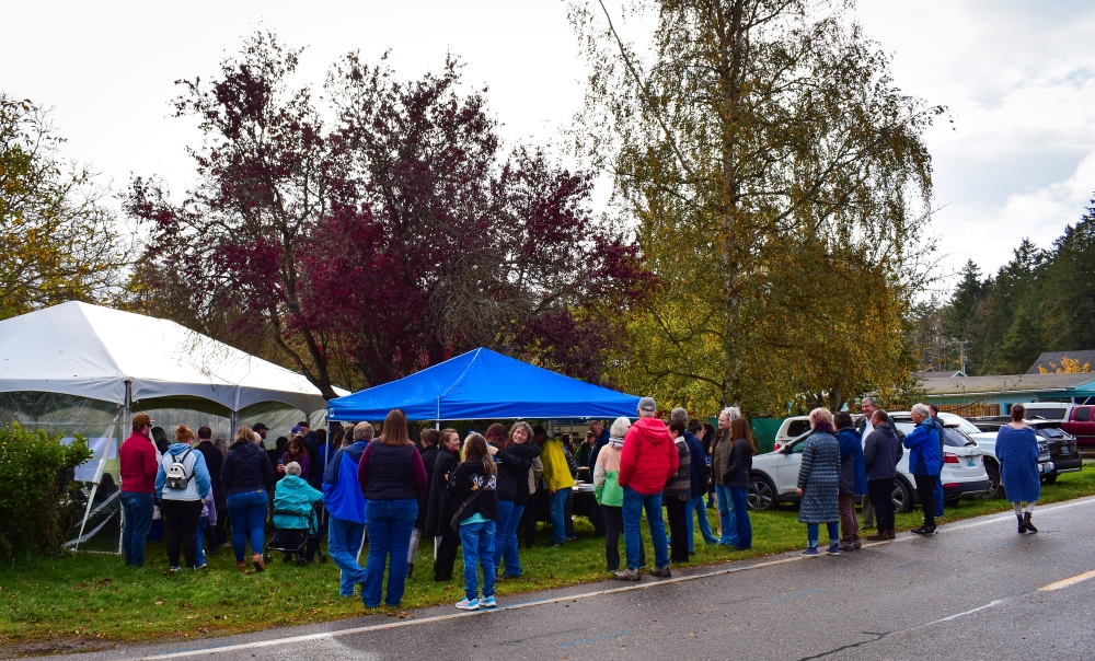 Attendees at Skagit Habitat for Humanity's Groundbreaking Ceremony taking cover from the rain under a tent