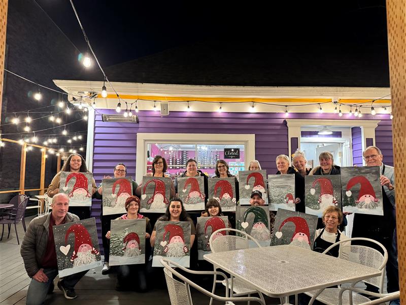 a group of people standing outside in front of Sugar Mama Cafe in Anacortes holding their canvases from The Speckeld Hen Paint Parties.