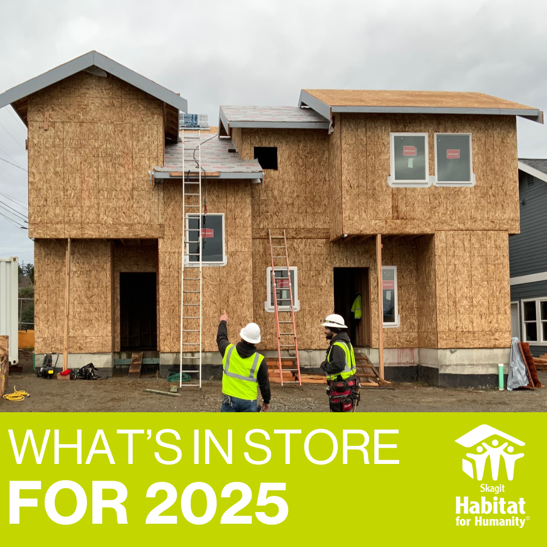 Construction site in Anacortes with two people in safety vests and hard hats pointing at it. With a green back with text that reads, "What's in Store for 2025"